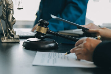 Business and lawyers discussing contract papers with brass scale on desk in office. Law, legal services, advice, justice and law concept picture with film grain effect