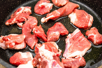 Raw meat pieces in a frying pan. Raw pieces of meat, pork for cooking.