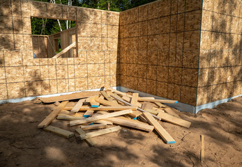 A pile of cut wood board leftover scraps, left in a heap at a constuction site.