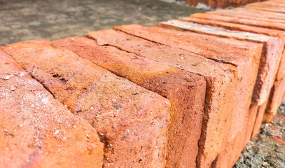 Selective focus. Red bricks from clay. Many clay is molded into bricks, after that it is laid out and dried in the yard in the sun before being burned to make it hard and dry. Pile of making batu bata