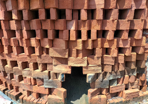 Selective focus. Red bricks from clay. Many clay is molded into bricks, after that it is laid out and dried in the yard in the sun before being burned to make it hard and dry. Pile of making batu bata