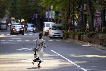 丸の内のオフィス街を走る女性