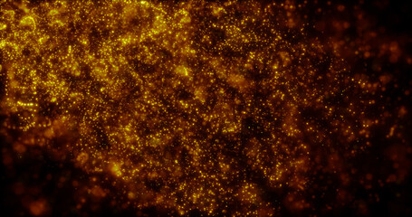 Blurred yellow abstract background of bokeh and small round particles of energy magical holiday flying dots on a black background