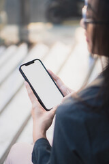 Young woman or teen girl hands holding smart phone with mockup white blank display