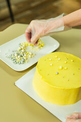 bright yellow cake for the holiday. the pastry chef decorates the cake with beads