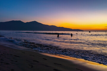 Sunrise at My Khe beach, Danang, Vietnam. Da Nang locals and tourists exercise along Da Nang beach,...
