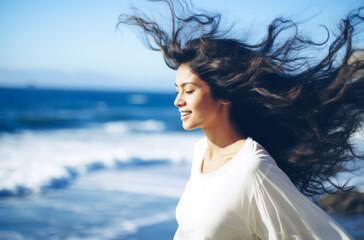Young woman with eyes closed enjoying her freedom by the sea coast