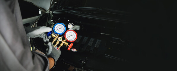 Hand of car mechanic technician use meter to check car air conditioner system heat problem and fix...