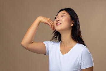 Fototapeta premium Asian woman wearing natural makeup and white t-shirt on beige background
