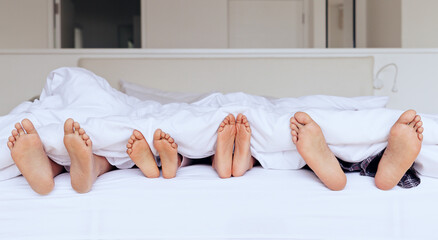 Family, feet and bed with blanket for sleeping, relaxing or rest together with calm and peace in...