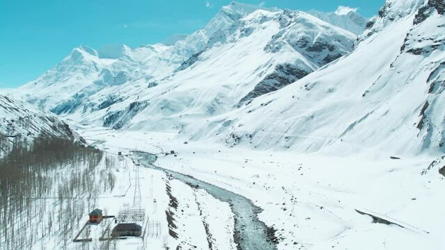 Aerial Backward Scenic Shot Of snowy mountains and flowing Chandra river in Lahaul, India. Winter landscape. Himalayas in winter. 