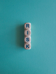 Risk. Word On wooden cubes on blue background. Business startup risk and crisis management concept.