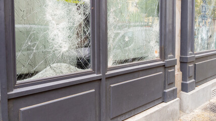 broken shop windows facade in town center smashed during protesters symbolizing the latest riots in...