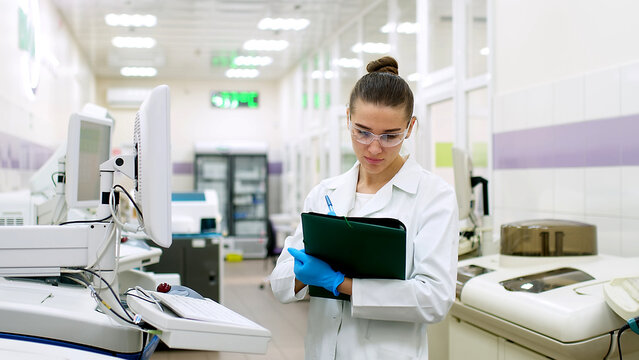 A female scientist controls the operation of devices for laboratory research. Modern laboratory technologies. Medical research centrifuge.