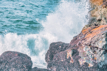 Water splashes close up. Crystal clear sea water beats against the rocks. Sea waves break on the...