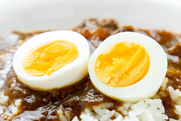 カレーライスにトッピングされたゆで卵のアップ。
