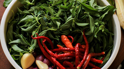 basil leaves, chilies and shallots in a container on the table