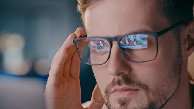 Close up shot of wearing glasses with reflect ukrainian attacked by russia in 2022 february. Video flashbacks about russian invasion. Upset man shocked looking first cadres from Bucha