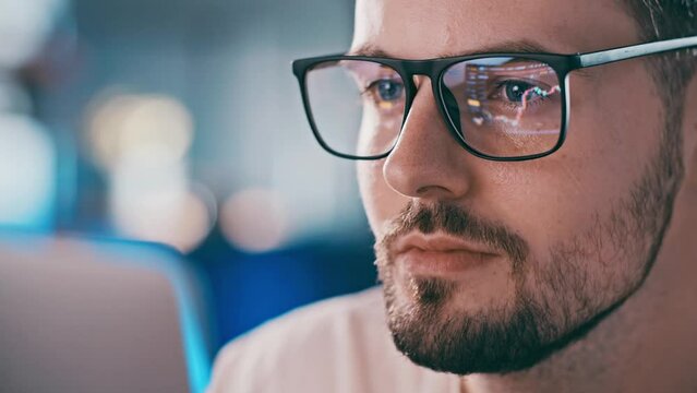Close up shot of man eyeglasses reflection showing stock market graphic. Trading charts in mirror. Experienced gambling master crypto exchange market analytic looking at screen