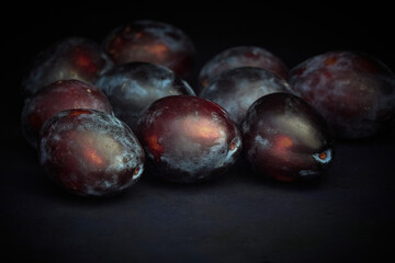 Obraz premium Ripe Prunes on a dark background
