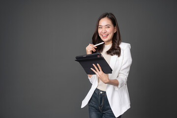 Young asian woman confident manager worker use modern technology digital tablet work remote distance isolated grey color background. Beautiful woman using smartphone. Lifestyle concept.
