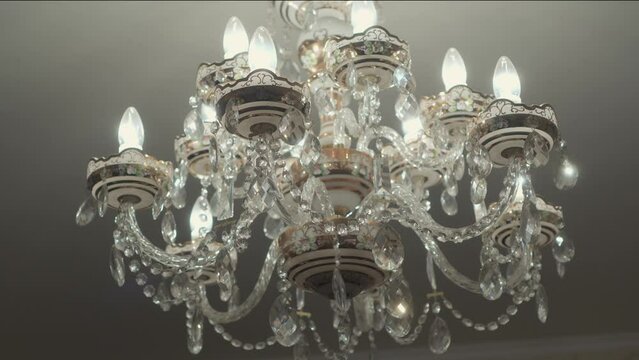 Antique crystal chandelier with candelabra and candle-shaped bulbs.