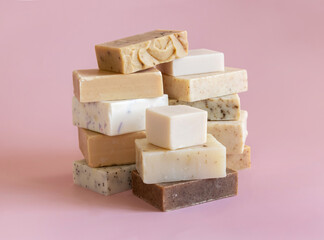 Beige and brown handmade soap bars on light pink close up. Natural herbal product for SPA