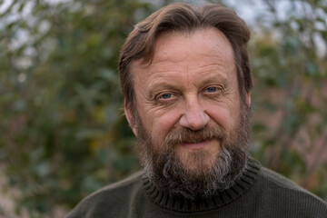 Portrait of a thinking or dreaming or solve problems senior man. Elderly bearded caucasian male in nature. Face bearded male daydream of decision, planning solution and insight of questions