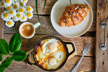 Breakfast. Croussant with chocolate and fried eggs.