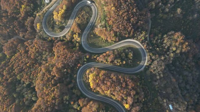 Curvy mountain roads in autumn. Vehicles in motion on winding mountain roads. 