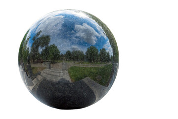 Granite ball on white background. Beautiful reflection of the sky and clouds.