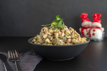 Traditional Russian Potato Salad Olivier for New Year's celebration on dark background.