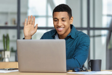 African American man manager working online uses laptop for video conference with employees or...