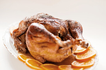 Delicious golden roasted Thanksgiving turkey on dinner table with pumpkins