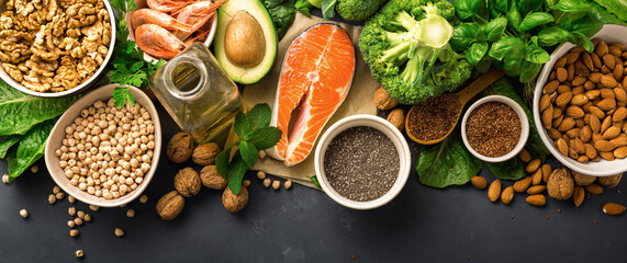 Food sources of omega 3 on dark background with copy space top view. Foods high in fatty acids including vegetables, seafood, nut and seeds. Health food fitness