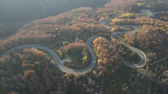 Curvy mountain roads in autumn. Vehicles in motion on winding mountain roads. 