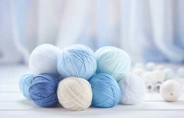 colorful balls of thread and metal knitting needles on a white wooden table for handicraft card design soft light