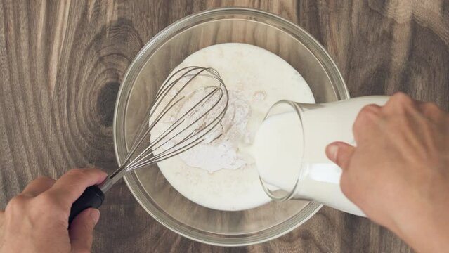 White chocolate vanilla bean instant pudding mix and milk in a glass bowl, flat lay.