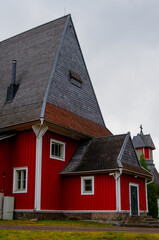 Fototapeta na wymiar Red wooden church build in 1693. The church is located in the church village of Iiti, Finland. Church has a high and pointed Dutch hip roof, sometimes called a Dutch gable roof.