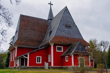 Red wooden church build in 1693. The church is located in the church village of Iiti, Finland. Church has a high and pointed Dutch hip roof, sometimes called a Dutch gable roof.