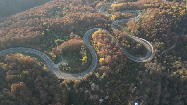 Curvy mountain roads in autumn. Vehicles in motion on winding mountain roads. 