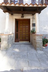 Image of a brown entrance door to a residential building with an antique façade