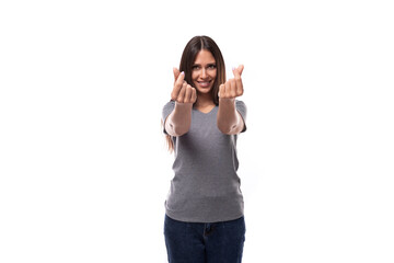 young european brunette woman dressed in a gray basic t-shirt crossed her fingers