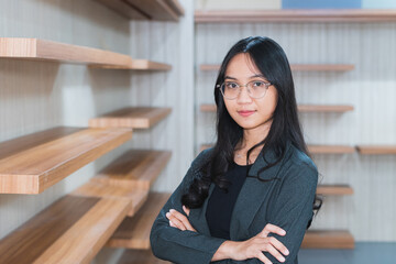 Asian businesswoman or freelancer standing near the desk in the office Dressed in formal clothes