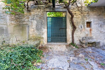 Image of a green entrance door to a residential building with an antique façade