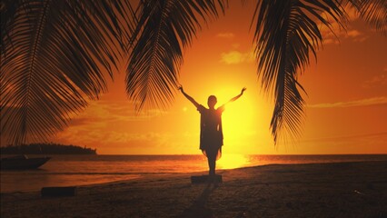 Woman silhouette against orange sunset sky. Young slim woman walking tropical island beach under the coconut palm tree branch. Relaxing, travel, tourism, exotic holiday vacation. - obrazy, fototapety, plakaty