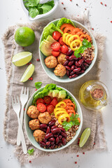 Spicy Mexican salad with groats, meatballs, vegetables and limes.
