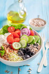 Fresh Greek salad with groats, vegetables and feta cheese.