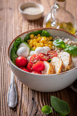 Fresh Caesar salad with chicken, groats and tomatoes.