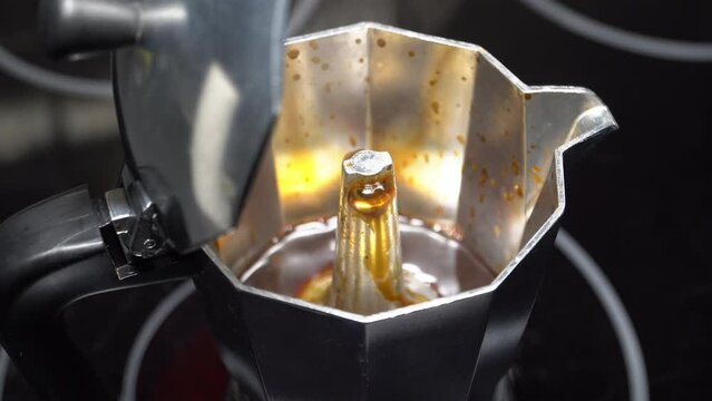 Close up shot of a boiling moka pot pressure coffee maker with open cover.